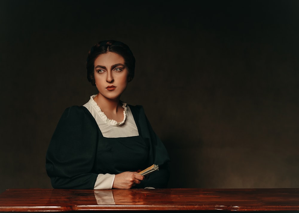 woman in black blazer sitting on brown wooden chair