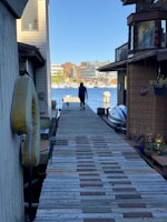 A solo dog walker strolling a happy golden retriever near the Empire Outlets on a sunny day.