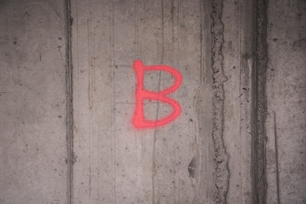 red letter b on gray wooden wall
