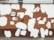 A brick wall with patches of white paint creating an irregular pattern against a predominantly brown surface. The wall features graffiti art, including a simple cartoonish figure and Russian text. The design and colors give a contrasted and eclectic feel to the urban setting.