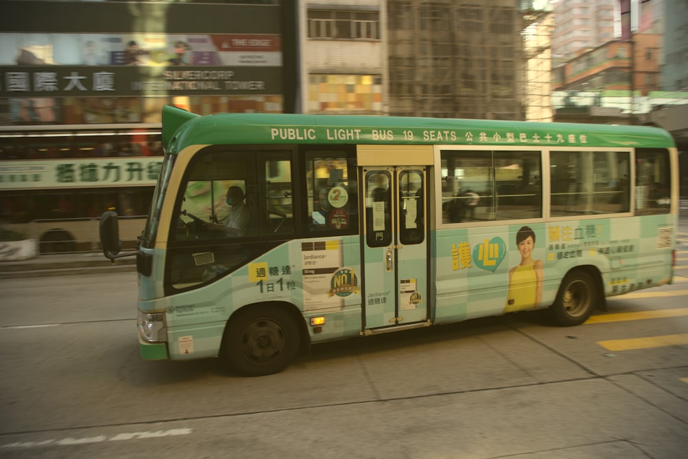 green and white bus on road during daytime