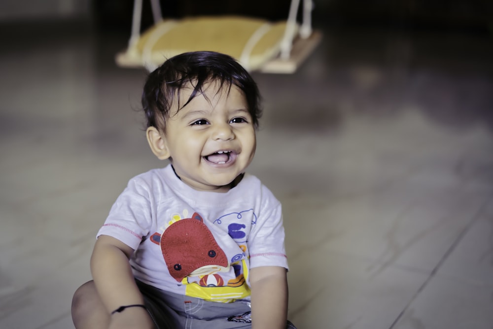 boy in blue and red crew neck t-shirt sitting on yellow and white chair