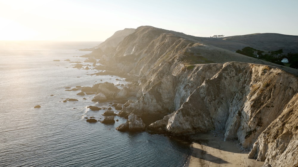 brown and green rock formation on sea during daytime