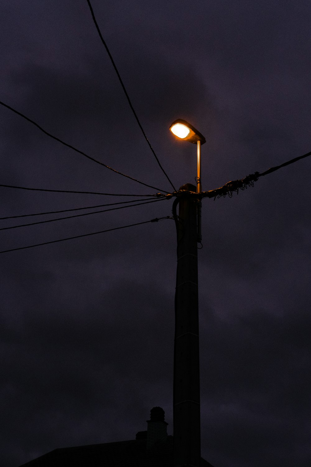 a street light on a pole with a cloudy sky in the background