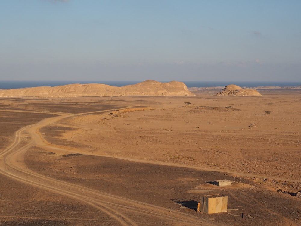 brown sand field under blue sky during daytime