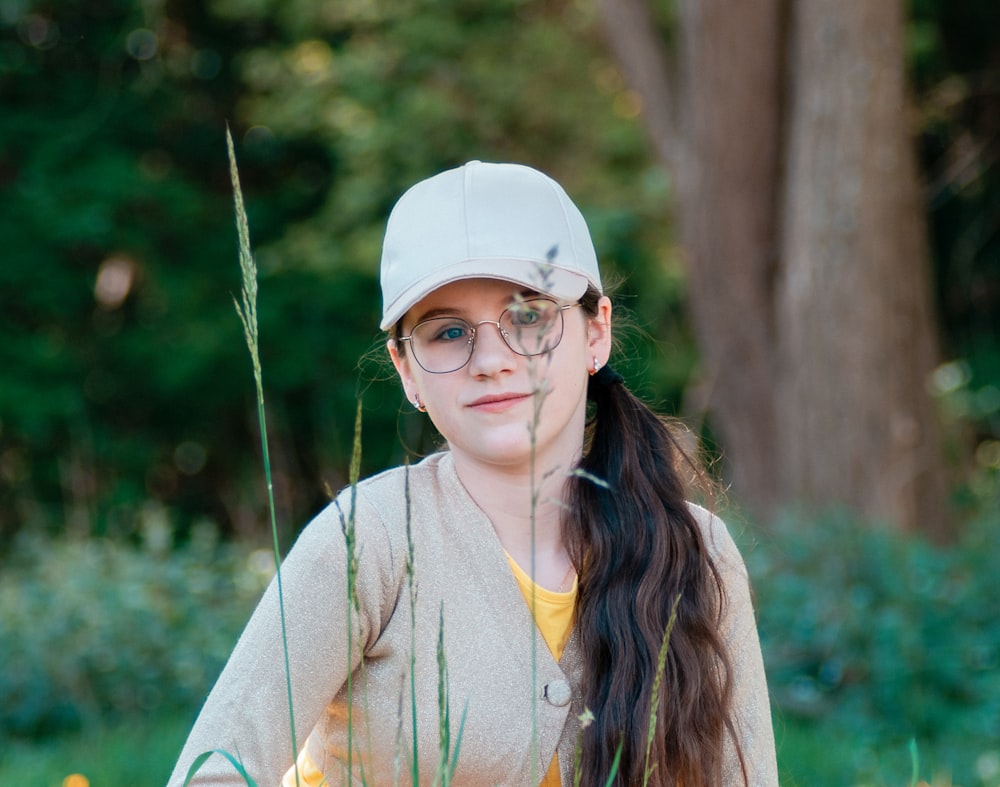 woman in white baseball cap and brown coat