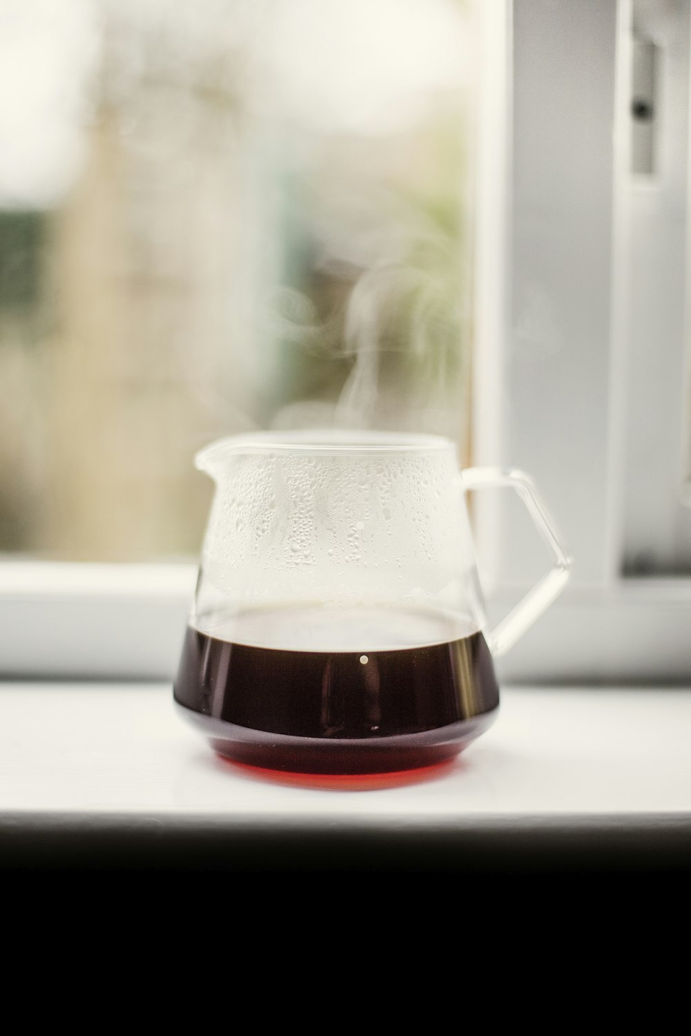 clear glass pitcher with brown liquid