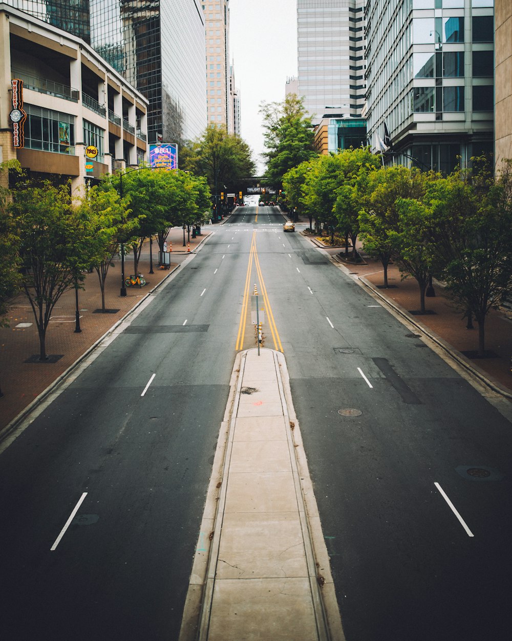 Carretera asfaltada gris entre edificios de gran altura durante el día