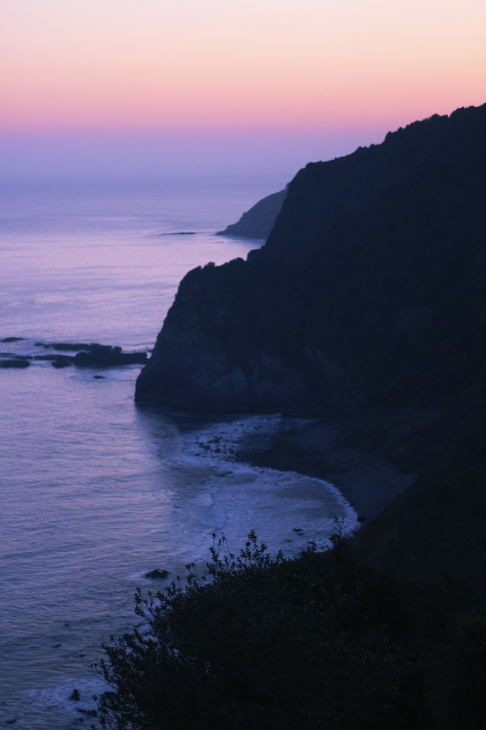 body of water near mountain during daytime