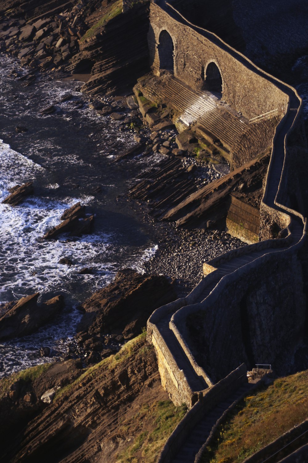 aerial view of brown concrete building near body of water during daytime