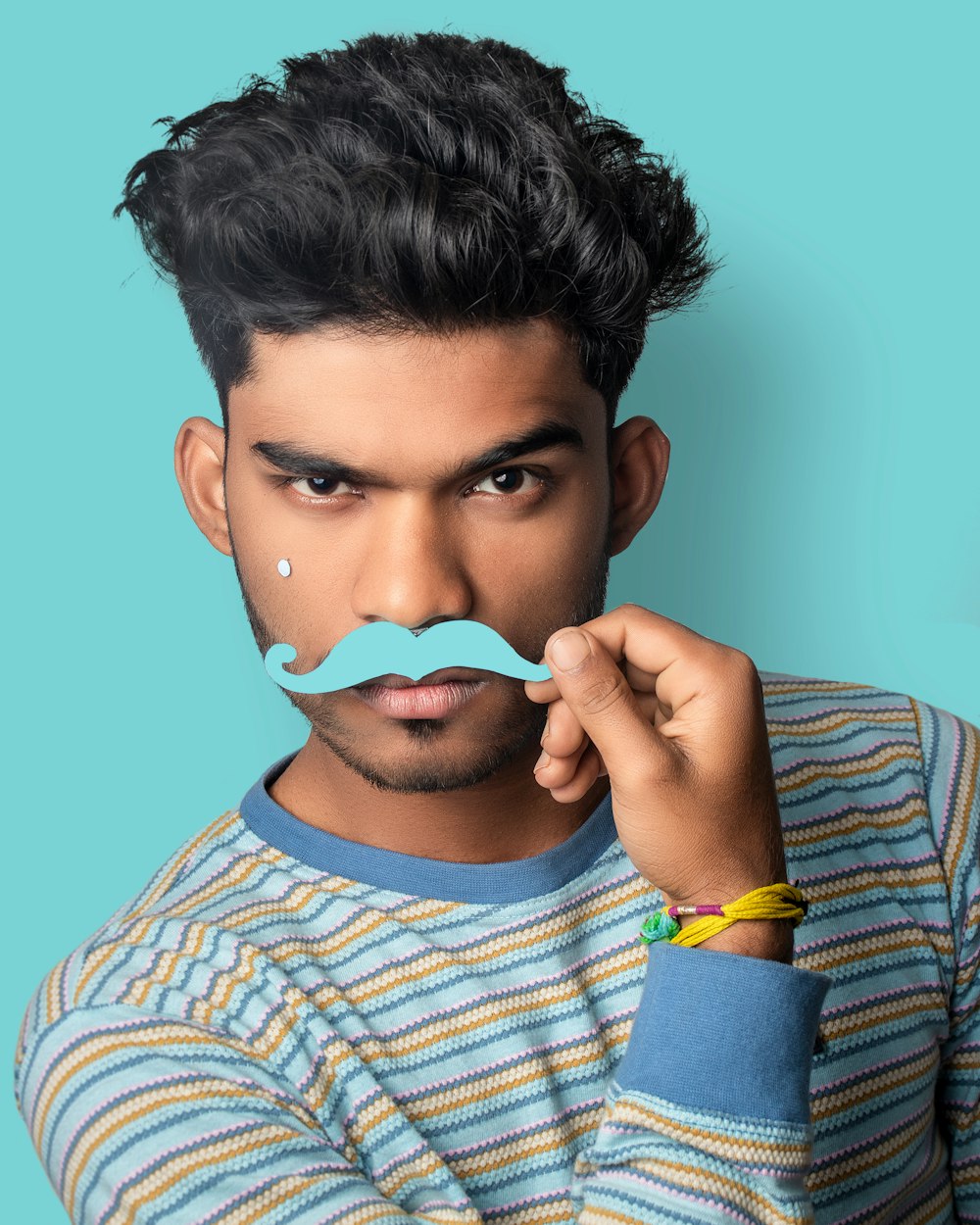 boy in blue and white striped crew neck shirt covering his face with white and blue