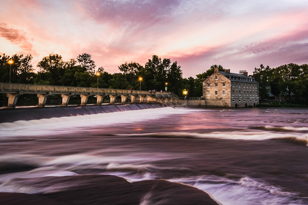 time lapse photography of river near trees and building