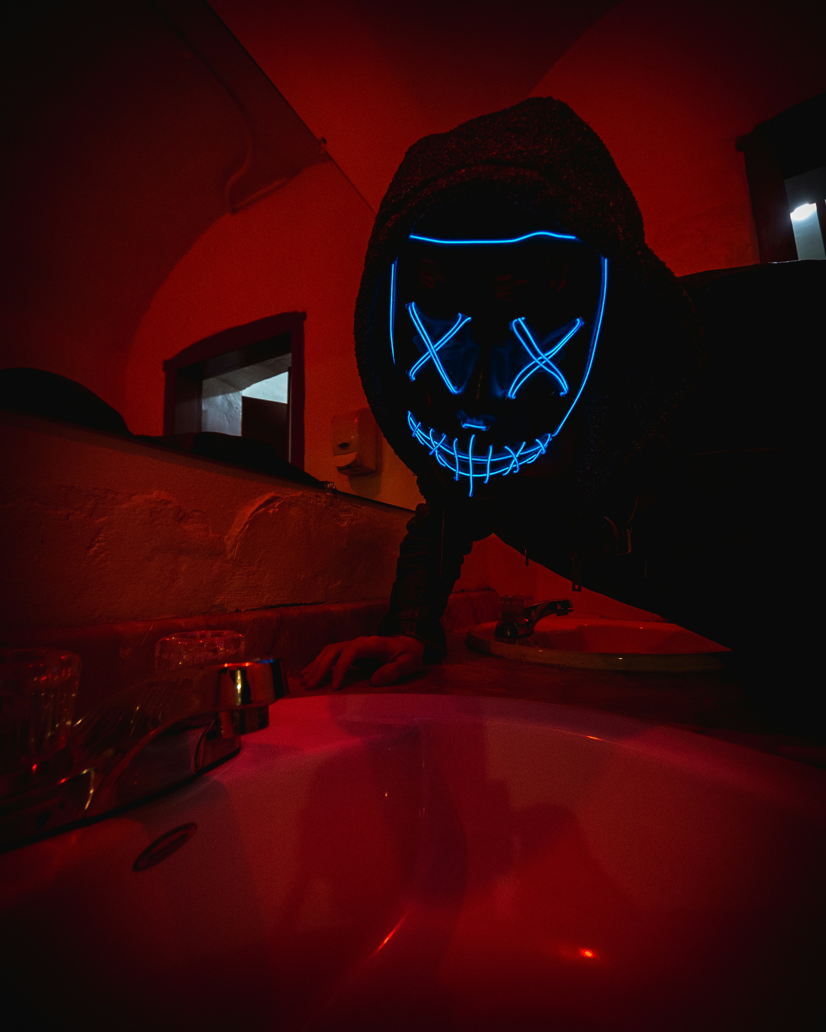 赤い車のボンネットの上に立っている黒と白のマスクの人の写真 Unsplashで見つけるハイ オタワ ジェイル ホステルの無料写真