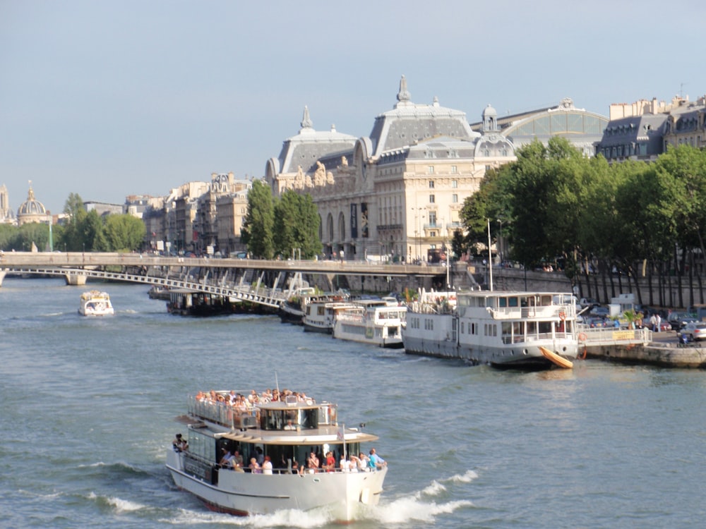 Bateau blanc et bleu sur l’eau près d’un bâtiment en béton blanc pendant la journée