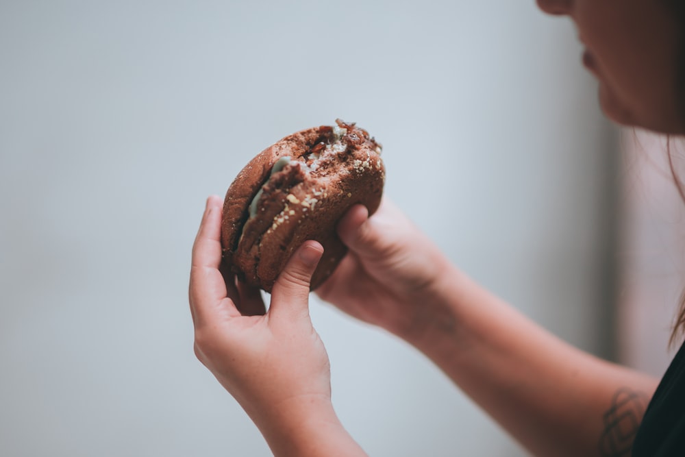 person holding chocolate chip cookie