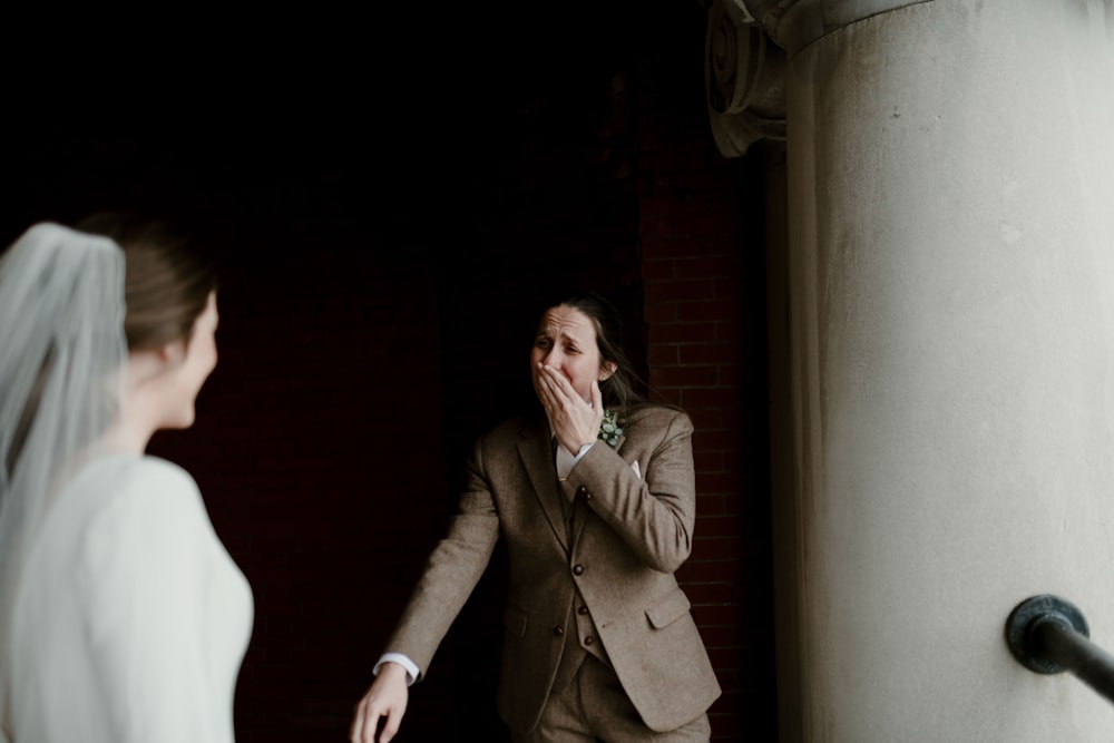 man in brown coat standing beside woman in white dress