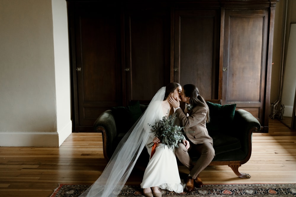 woman in white wedding gown sitting on brown wooden floor