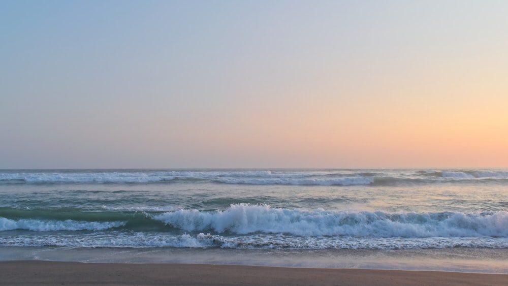 ocean waves crashing on shore during daytime