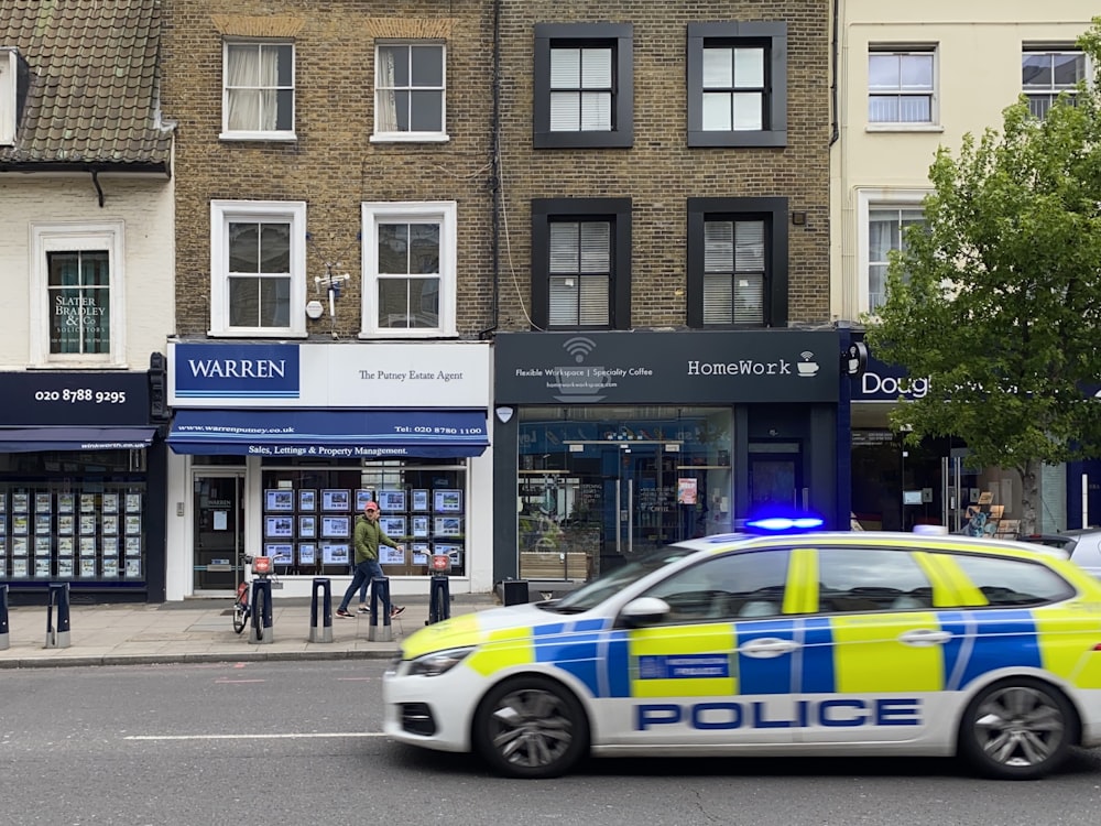 white and blue police car parked in front of building during daytime