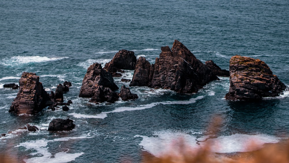 brown rock formation on body of water during daytime