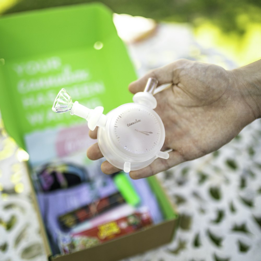 person holding green plastic container