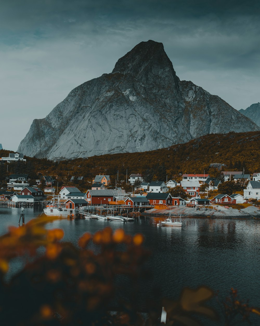 white and brown boat on water near mountain during daytime