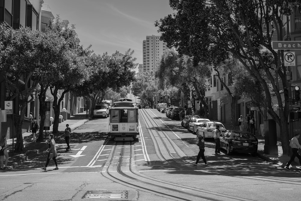 grayscale photo of people crossing on pedestrian lane