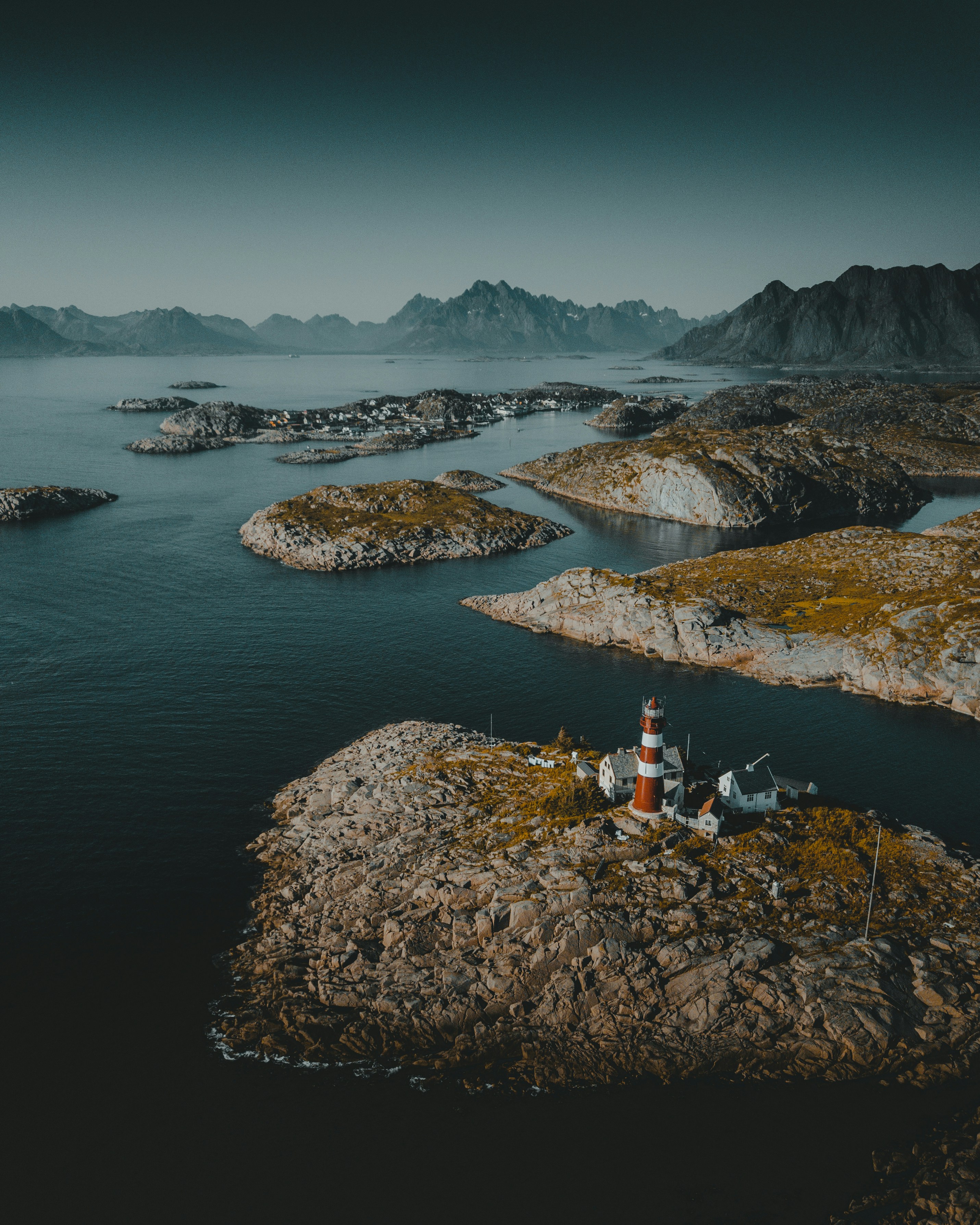 White lighthouse on brown rock formation near body of water during ...