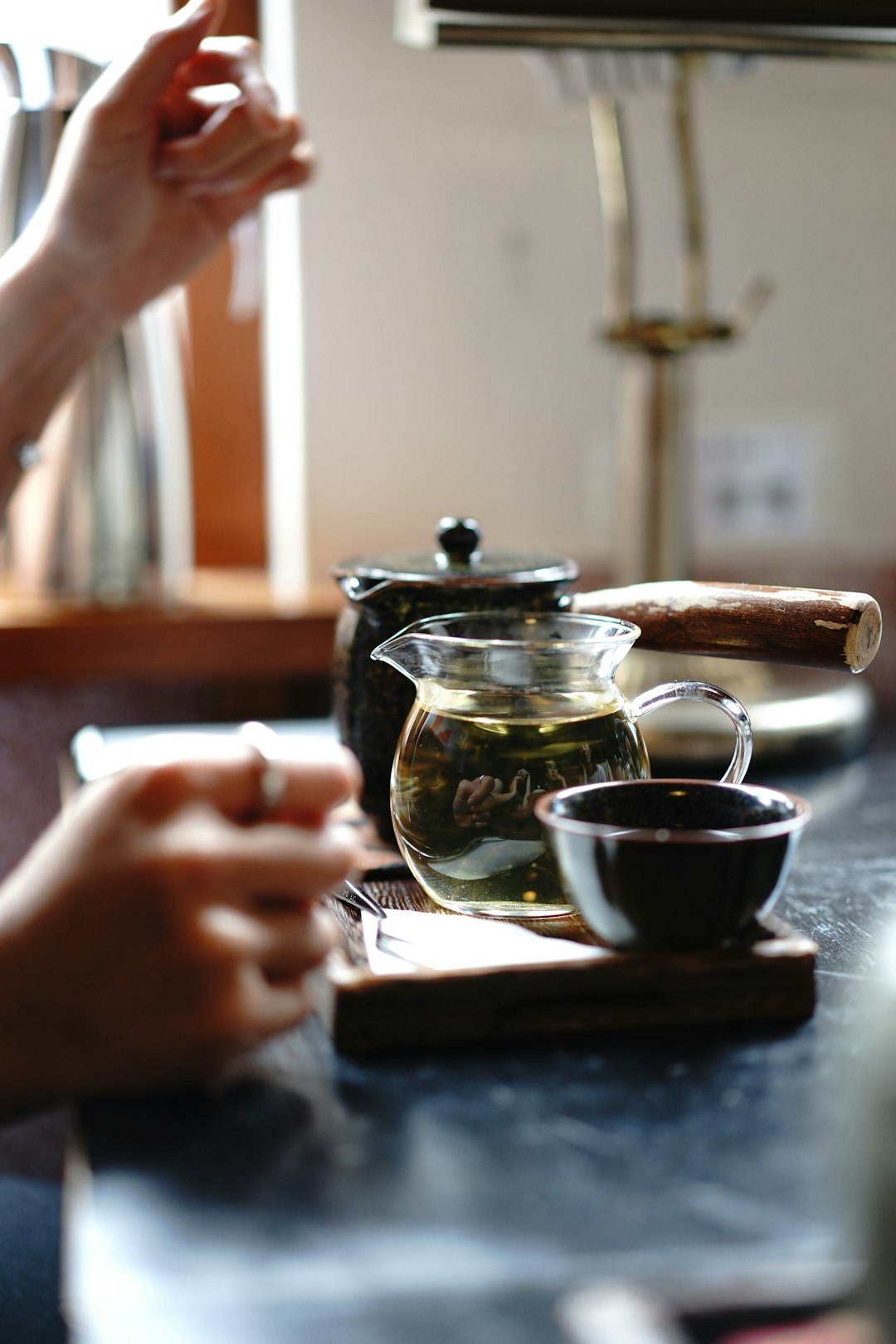 person pouring tea on black ceramic cup
