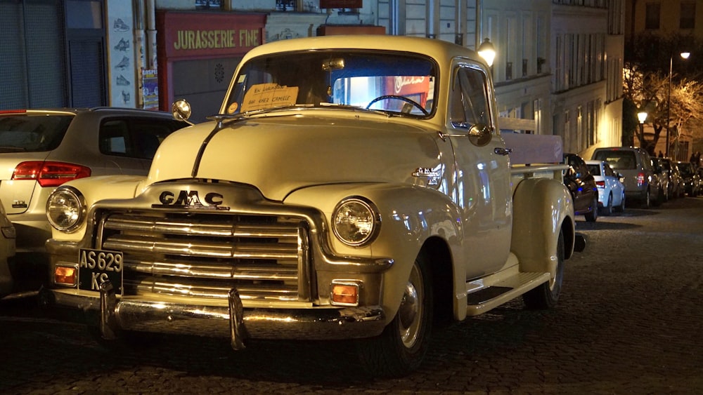 white vintage car parked in front of white building