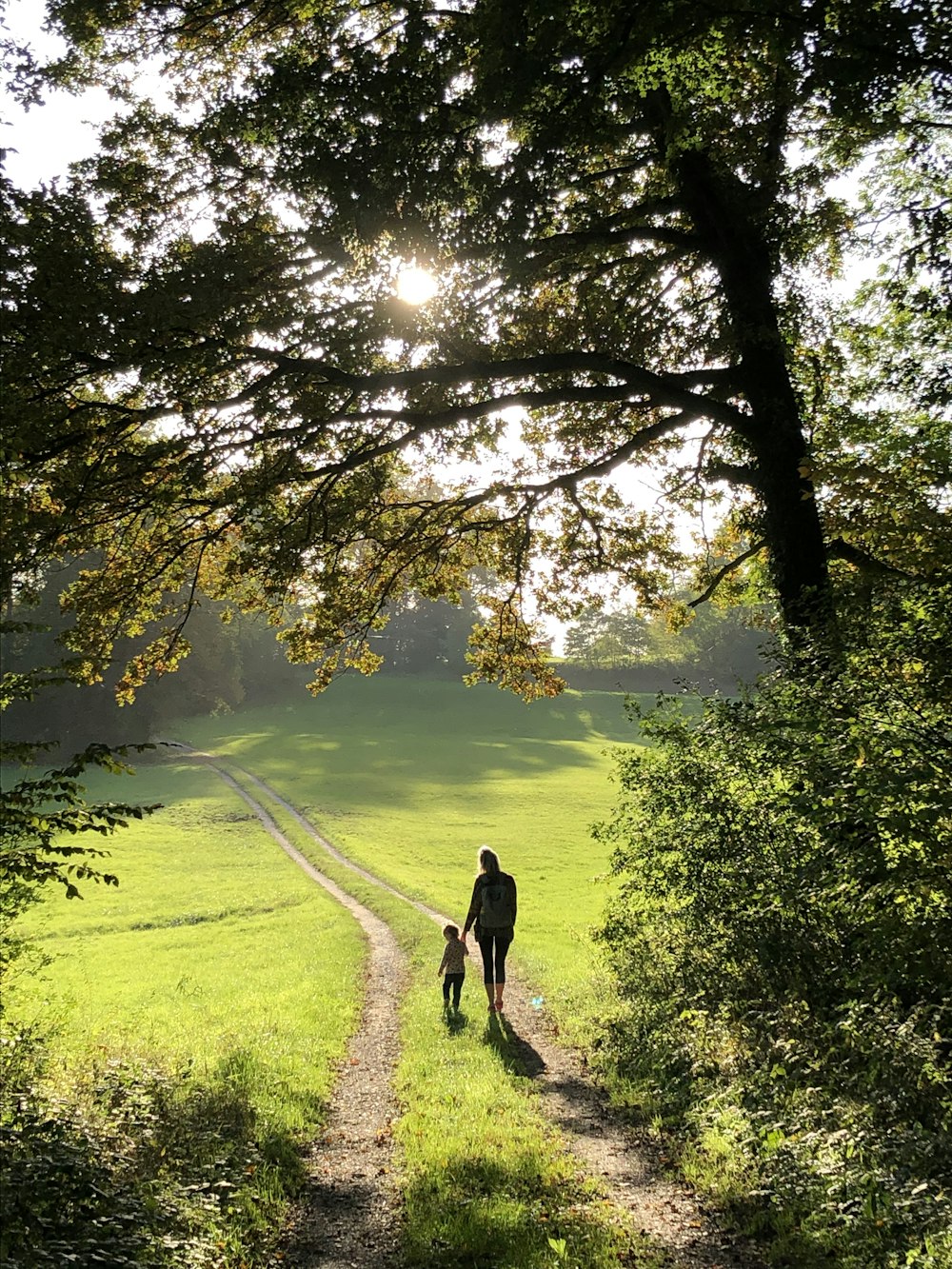 man in black jacket walking on green grass field during daytime