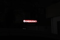 A bright red neon sign with the word 'Emergency' written, accompanied by a left-pointing arrow, stands out in a dark environment. Below, the word 'Parking' is faintly visible, indicating a parking area nearby.