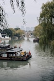 Peaceful riverside scenery in Jieyang with traditional boats floating gently.
