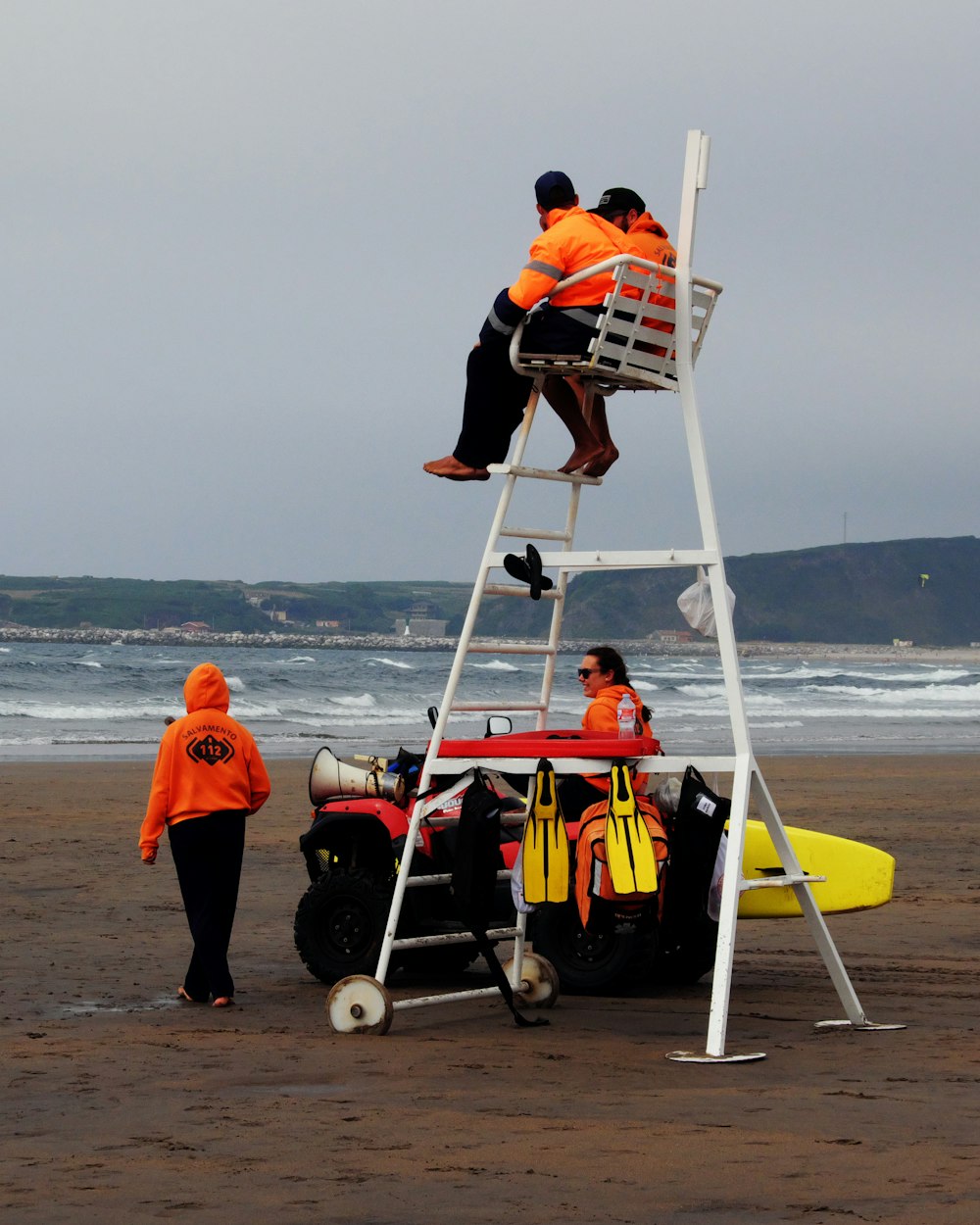 man in black shirt and black shorts sitting on red and white inflatable boat on beach