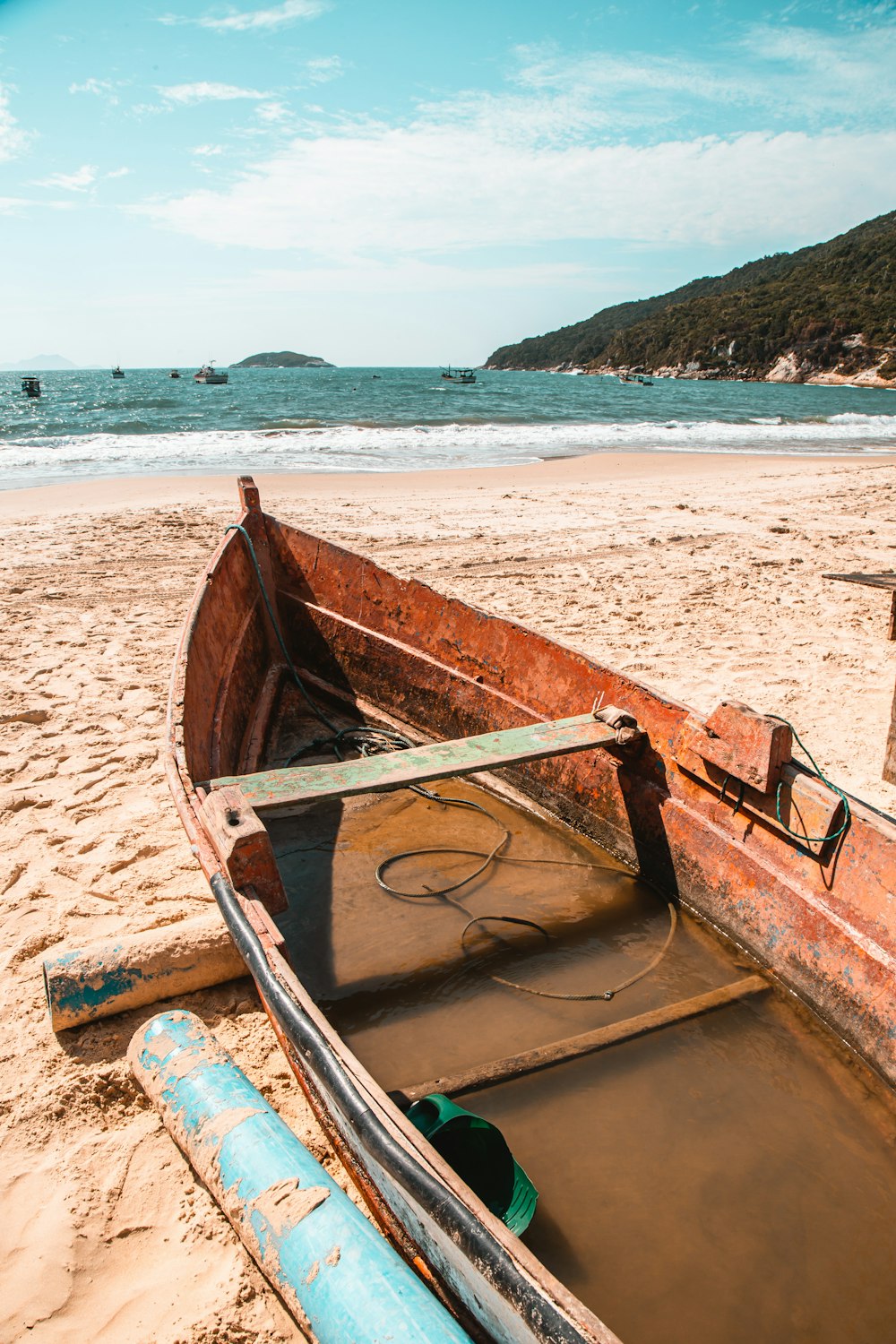 barco marrom na areia marrom perto do corpo de água durante o dia