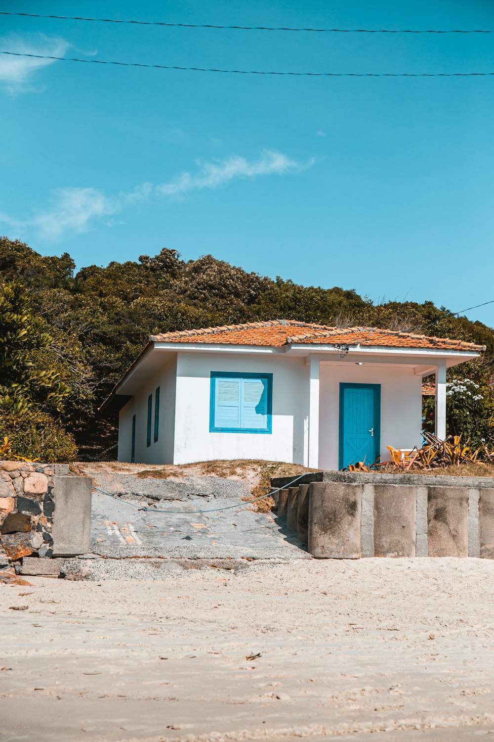 white and brown concrete house near green trees under blue sky during daytime