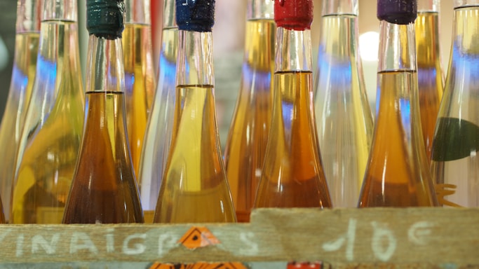 A variety of colorful beverage bottles arranged on a wooden table.