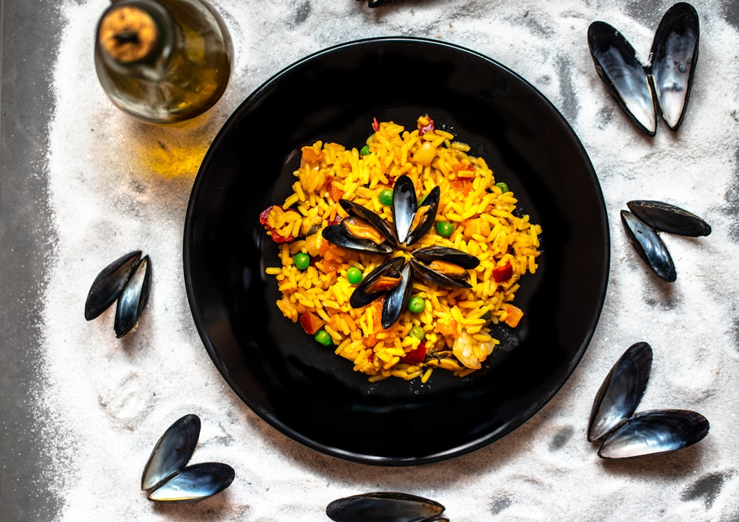 yellow flowers on black round plate, paella with mussels