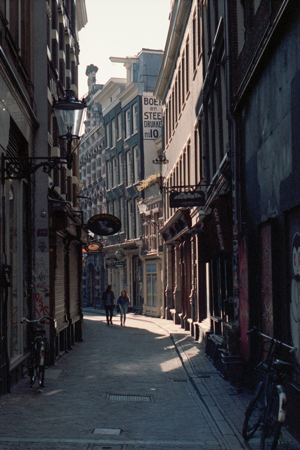 people walking on sidewalk between buildings during daytime