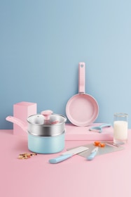 Close-up of pastel pink baking utensils arranged neatly on a soft pastel background.