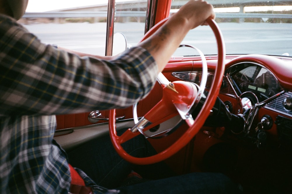 person in black and white plaid long sleeve shirt driving car