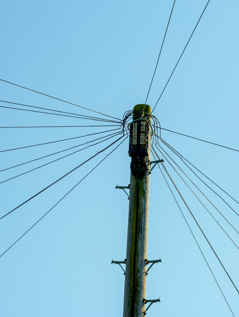 poste elétrico preto sob o céu azul durante o dia