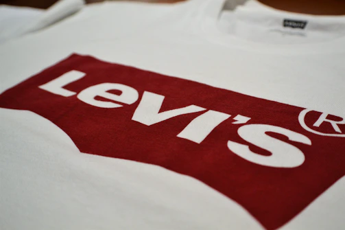 A vibrant red t-shirt featuring a detailed embroidered logo in contrasting white thread.