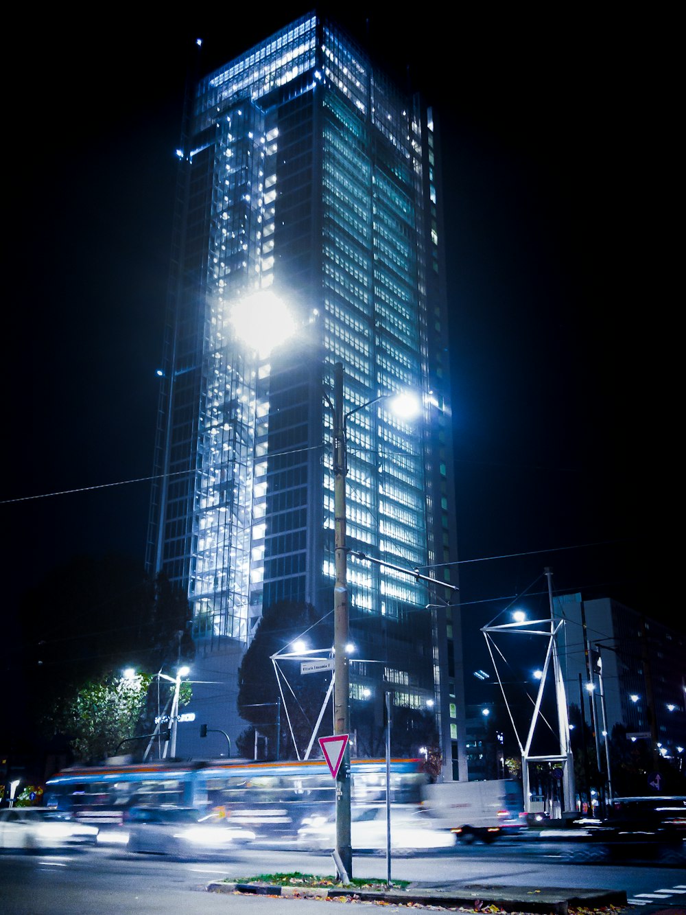 cars on road near high rise buildings during night time