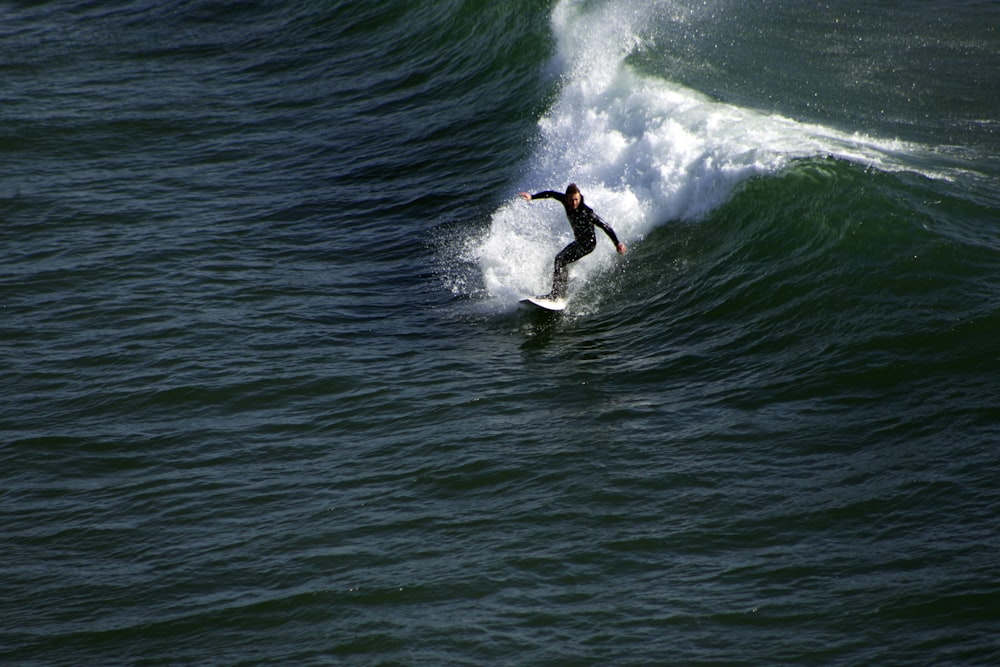 man surfing on sea waves during daytime