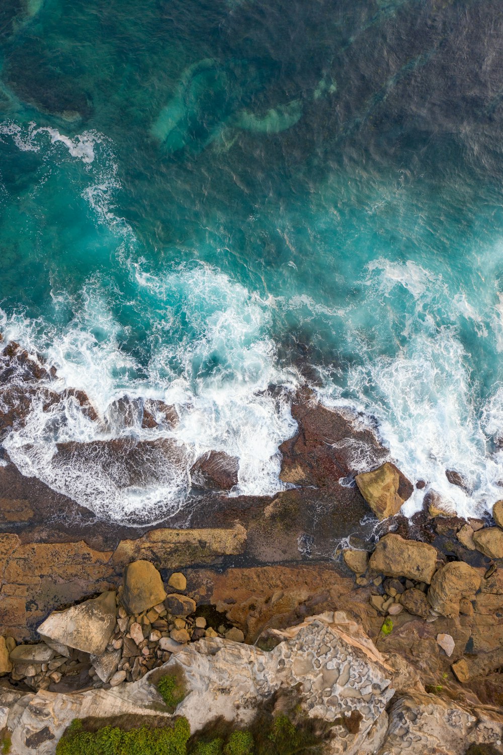 brown rocks beside body of water