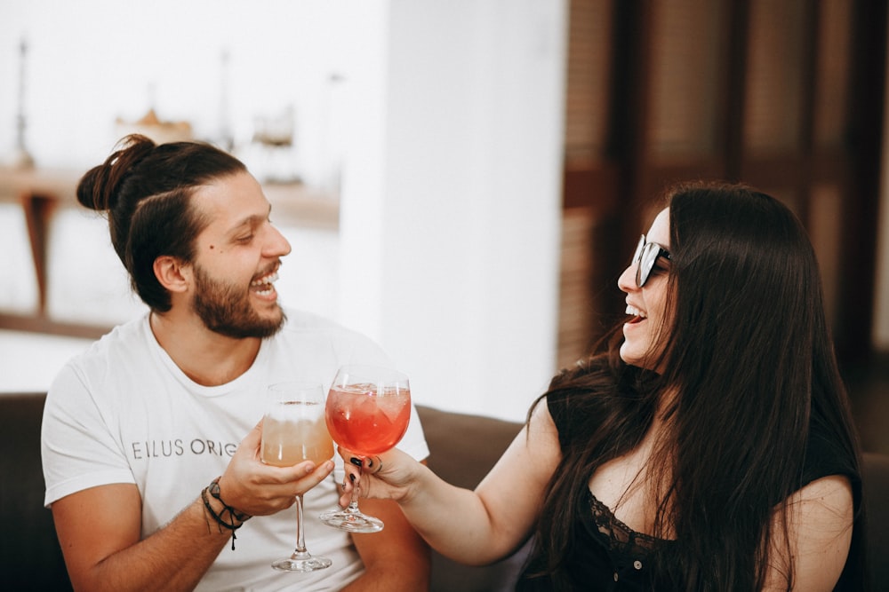 Two people holding drinks and laughing