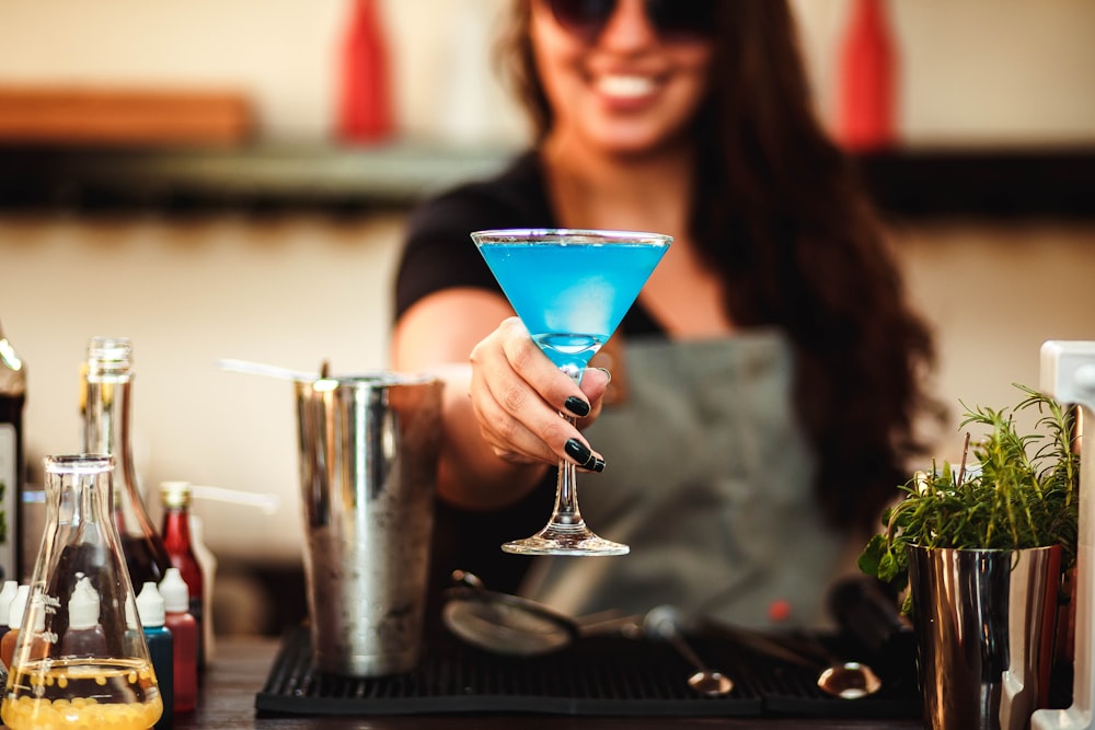 woman in black framed eyeglasses holding cocktail glass