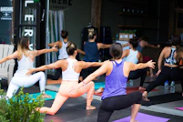 woman in white tank top and pink leggings doing yoga