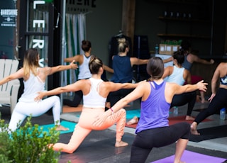 woman in white tank top and pink leggings doing yoga